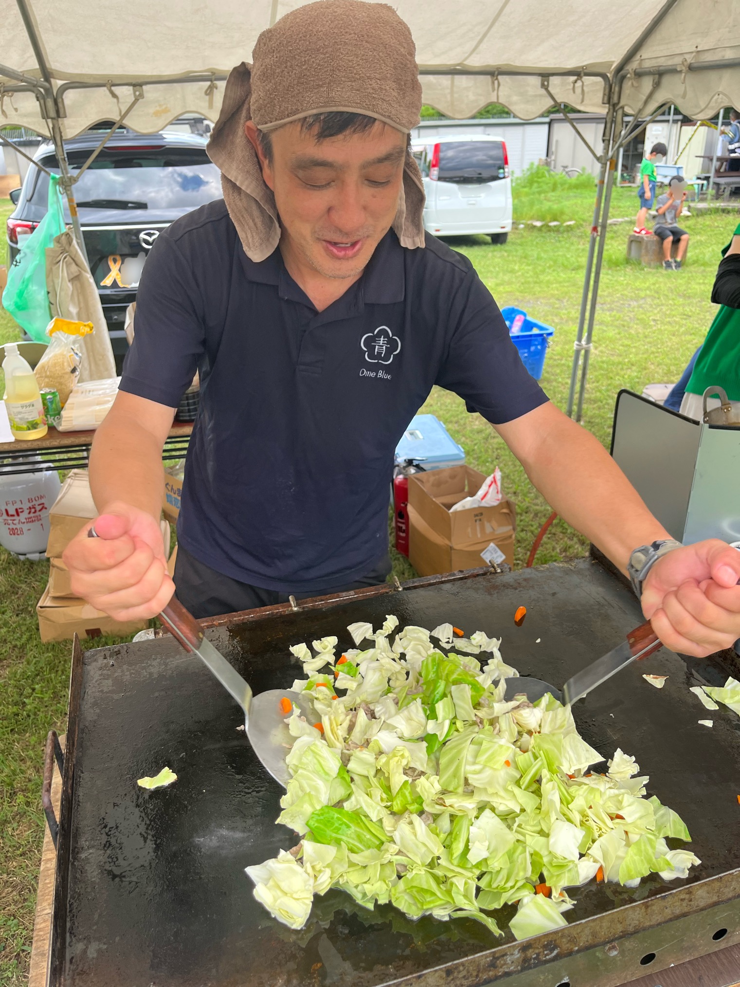 地域のお祭りで鉄板調理を手伝う片谷洋夫